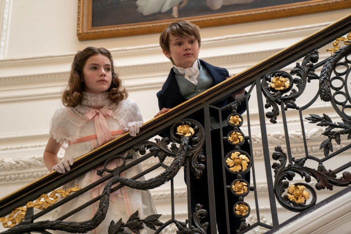 Children in period clothing on a grand staircase