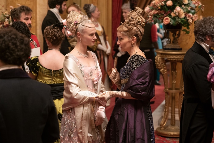 Two women in elaborate gowns at a Bridgerton event