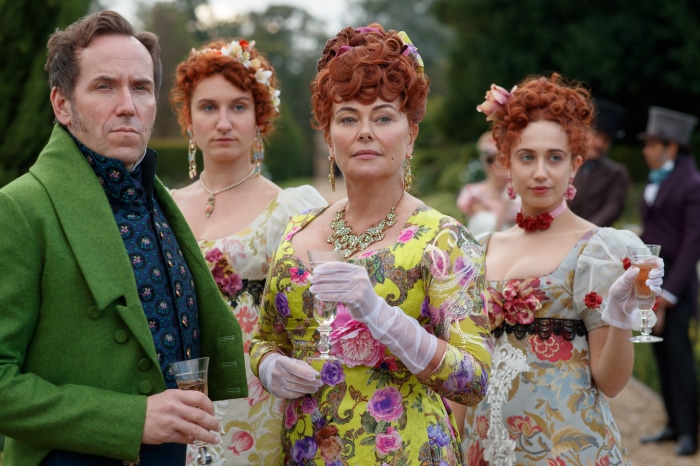 Four people in Regency-era attire at an outdoor gathering