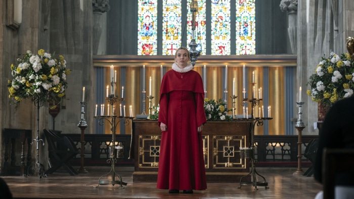 Jodie Comer in a red robe in a church