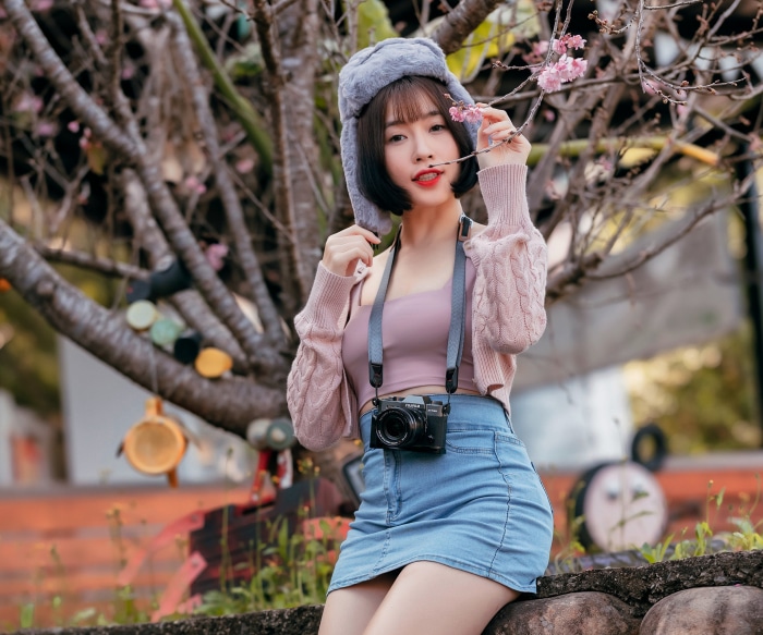 Asian woman with short hair wearing a hat and skirt