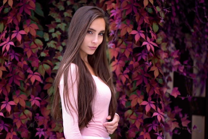 Brunette woman in pink shirt with autumn leaves