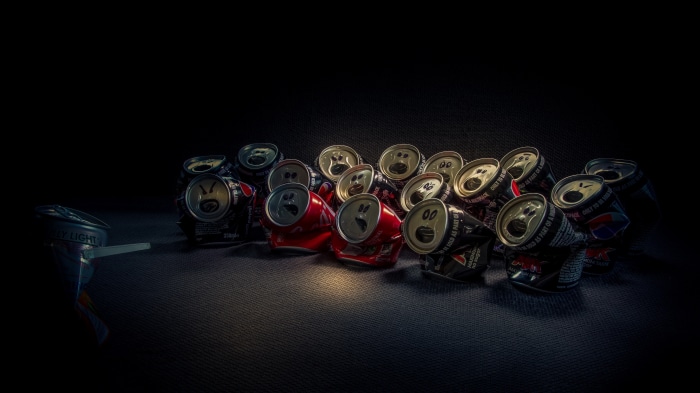 Crushed soda cans with drawn faces