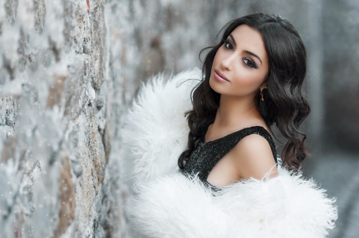Woman with black hair and white fur coat