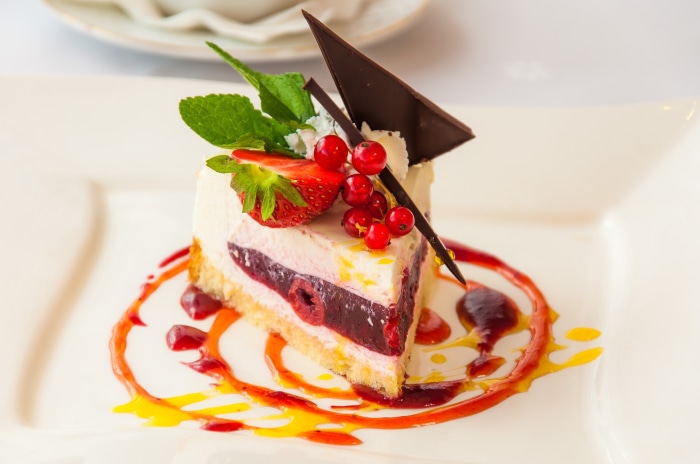Slice of berry cake with strawberry and currants