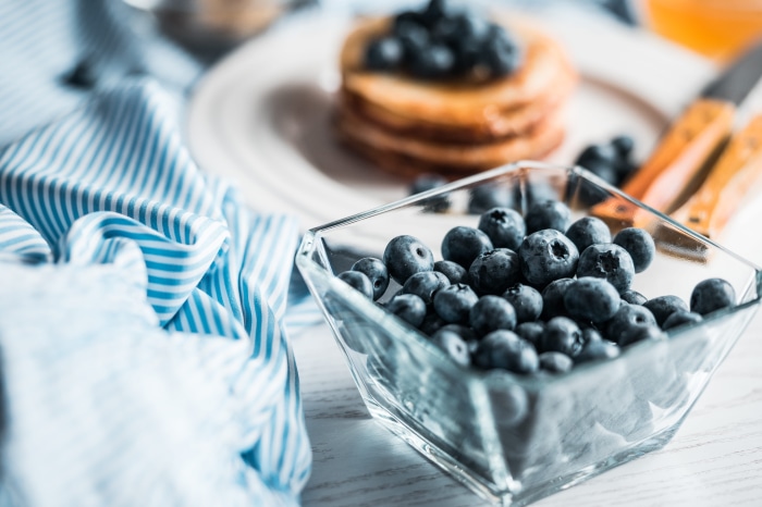 Blueberries in a bowl with pancakes