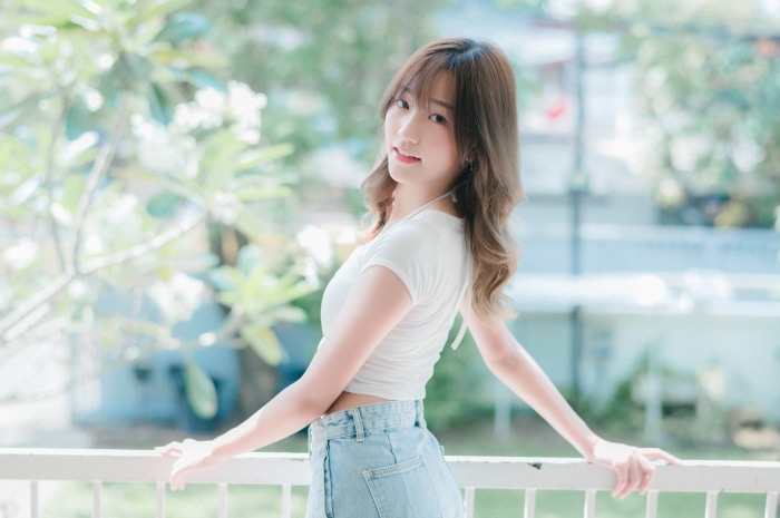 Asian woman in white top and denim shorts
