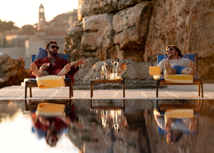 Nicolas Cage and Pedro Pascal relaxing by a pool