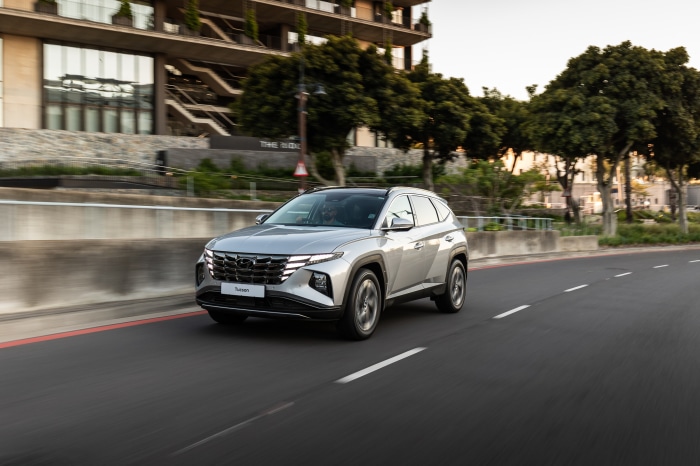 Silver Hyundai Tucson driving on a road