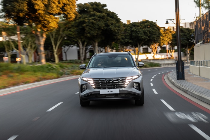 Silver Hyundai Tucson driving on a road