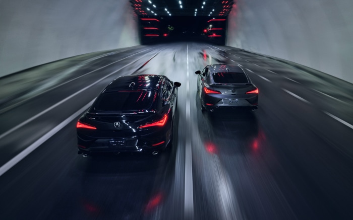 Two Acura Integras driving in a tunnel