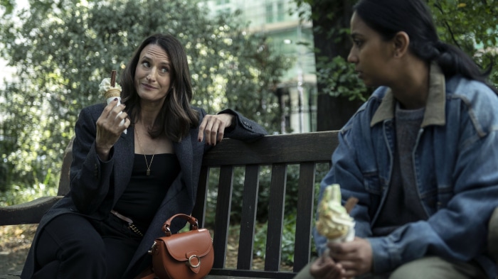 Two women eating ice cream on a bench
