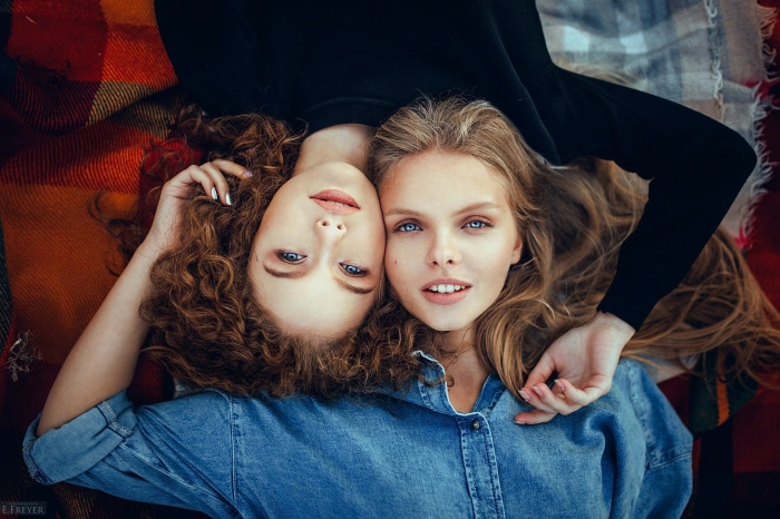 Two young women lying on a blanket