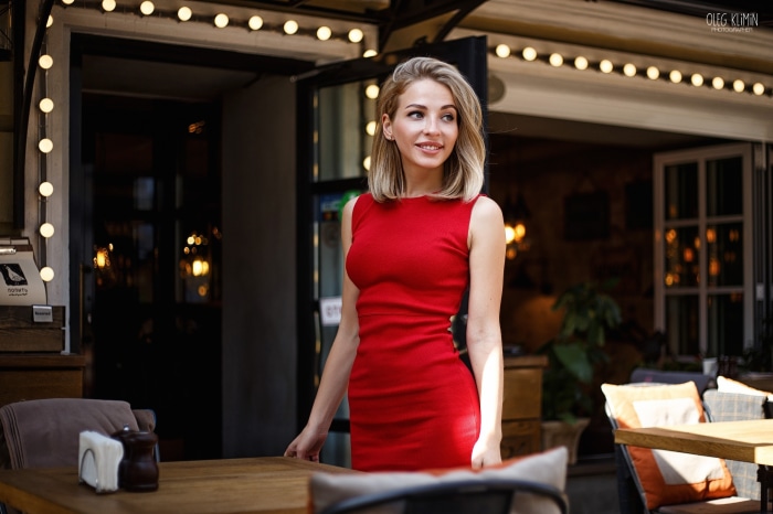 Woman in red dress standing outside cafe