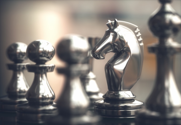 Close-up of a silver chess set with a knight in focus