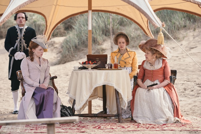 People in period clothing at a beach picnic