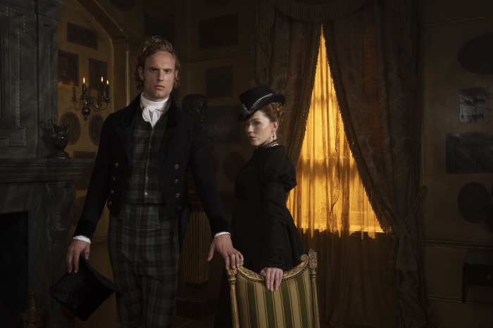 Man and woman in period costumes in a room