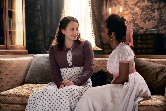 Two women in period dress sitting on a sofa in Sanditon