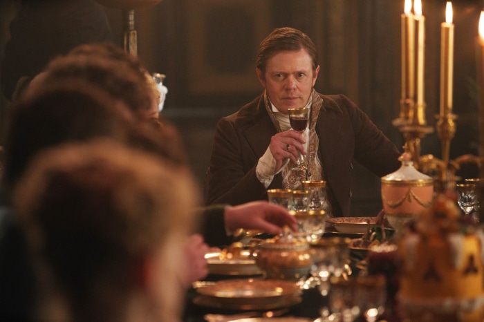 Man drinking wine at a formal dinner in Sanditon