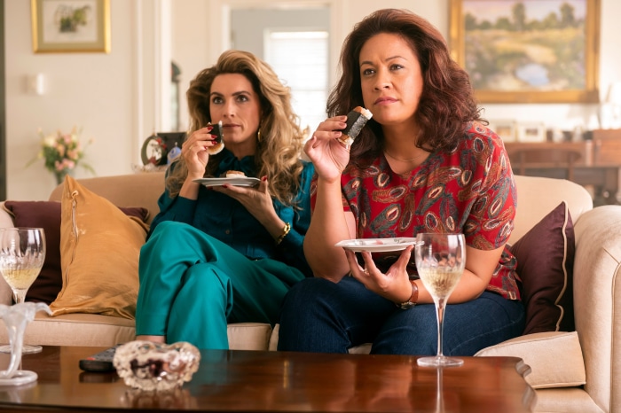 Two women eating snacks on a couch