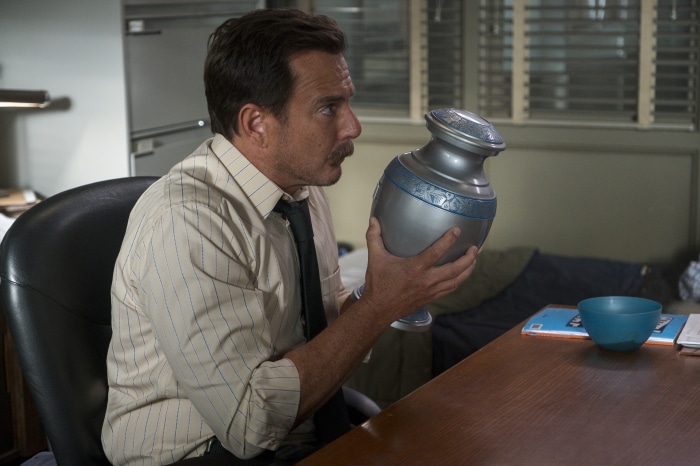 Will Arnett from Murderville holding an urn