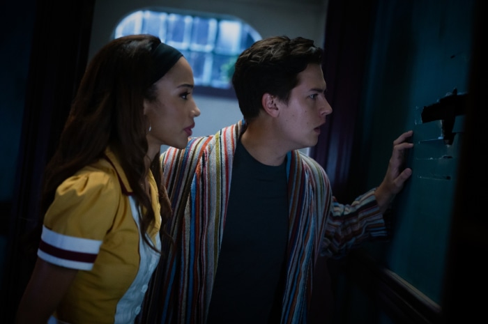 Jughead Jones from Riverdale looking through a hole in the wall