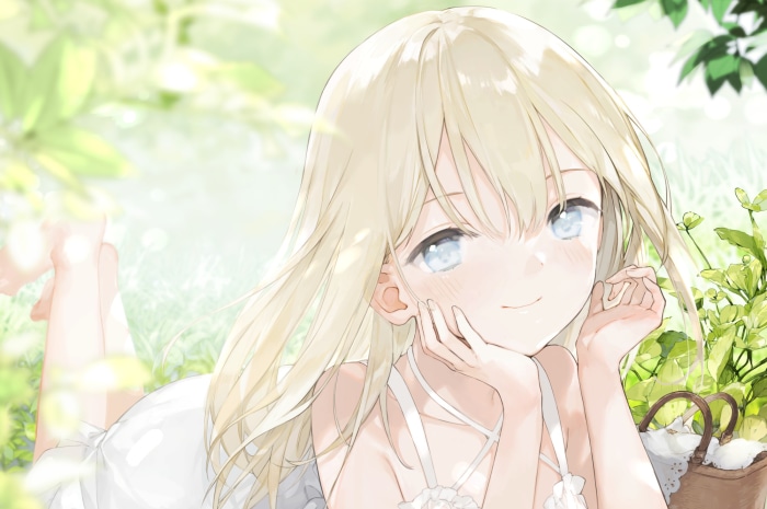 Girl with blonde hair and blue eyes lying in grass