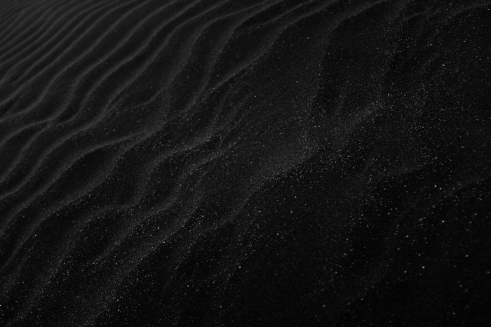 Black sand dunes with wavy patterns