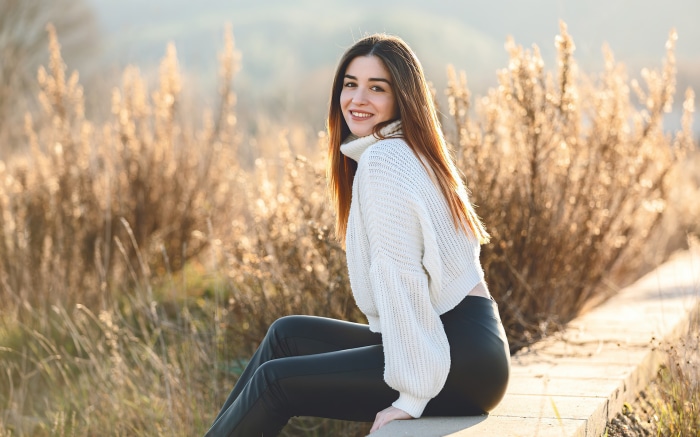 Girl Smiling in a White Sweater Outdoors