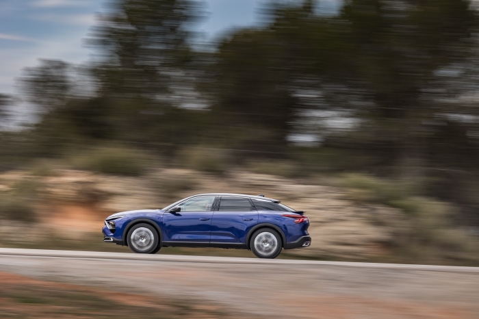 Blue Citroën C5 X driving on a road