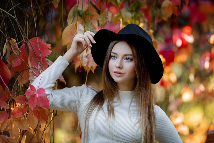 Woman wearing a black hat and white sweater