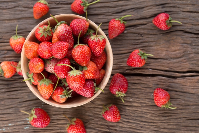 Strawberries in a bowl on a wooden table