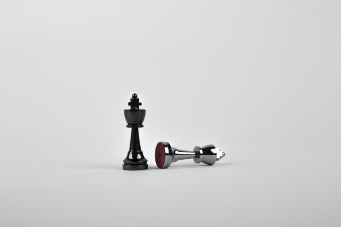 Black and silver chess kings on a white background