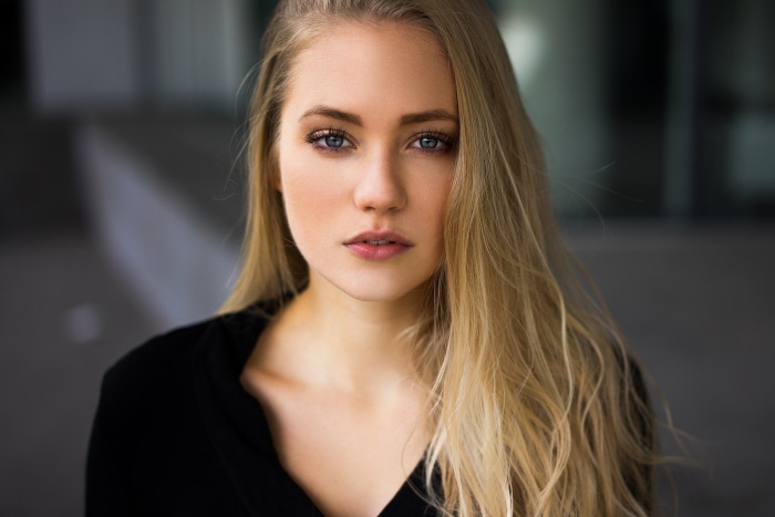 Woman with blonde hair wearing a black top