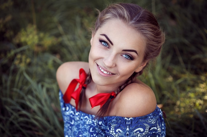 Woman with blue eyes and pigtails with red ribbons