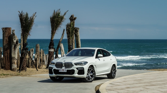 White BMW X6 parked by the ocean