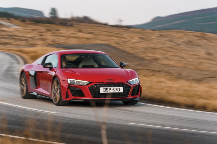Red Audi R8 V10 driving on a winding road