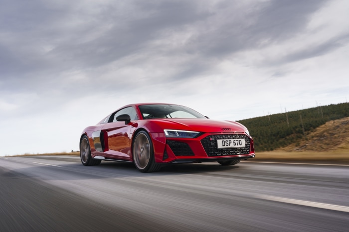 Red Audi R8 V10 driving on a road