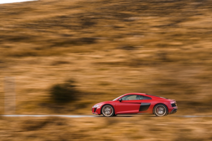 Red Audi R8 V10 driving on a road