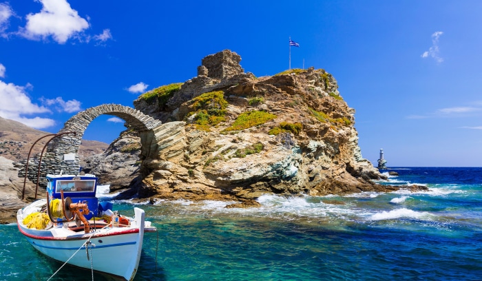 Boat and stone arch in Andros, Greece
