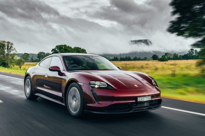 Red Porsche Taycan driving on a road
