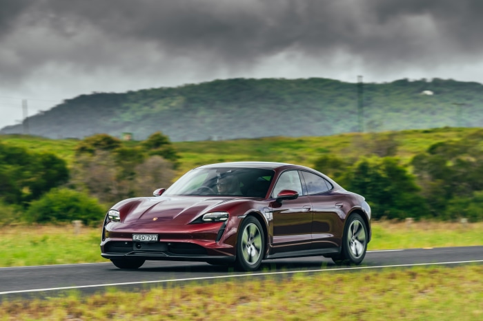 Red Porsche Taycan driving on a road