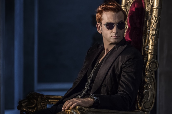 Crowley from Good Omens sitting on a throne