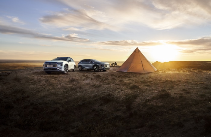 Mitsubishi Airtrek cars and tent at sunset