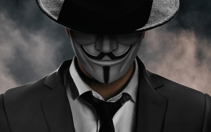 Man wearing Anonymous mask and hat