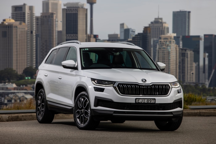 White Skoda Kodiaq SUV in front of city skyline