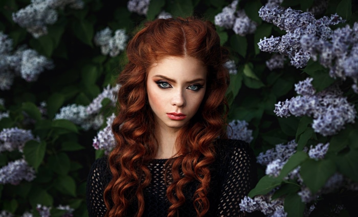 Redhead woman with curly hair and blue eyes