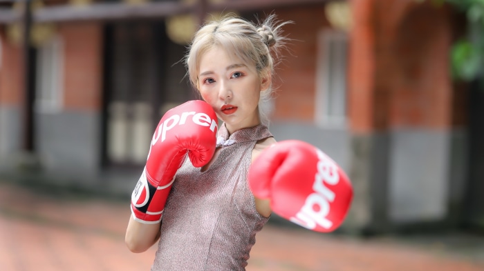 Asian woman wearing boxing gloves