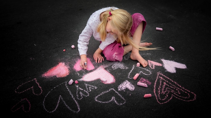 Little Girl Drawing Hearts with Chalk