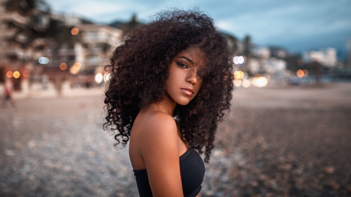 Woman with curly hair on a beach at dusk